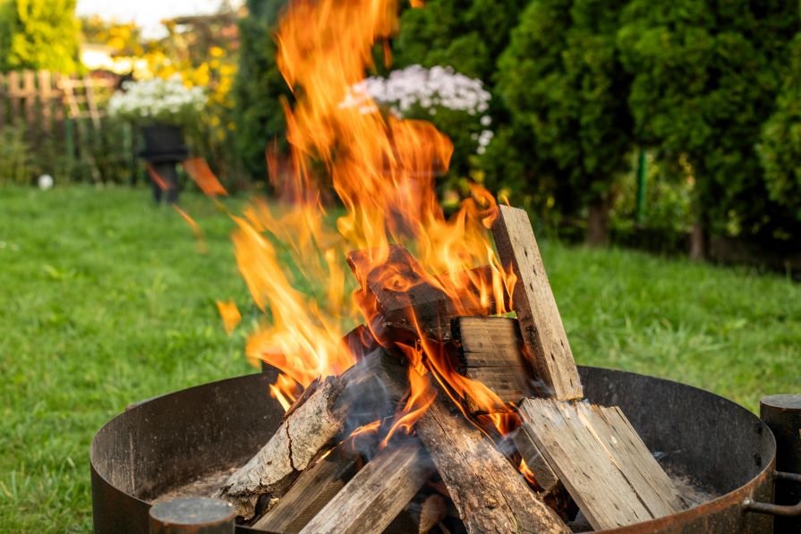 Feuerschale mit Holz im Garten